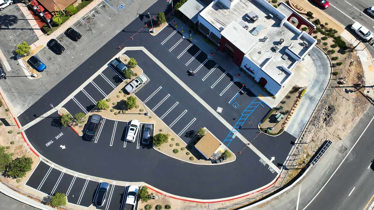 Aerial view of a freshly paved and striped commercial parking lot in Southern California